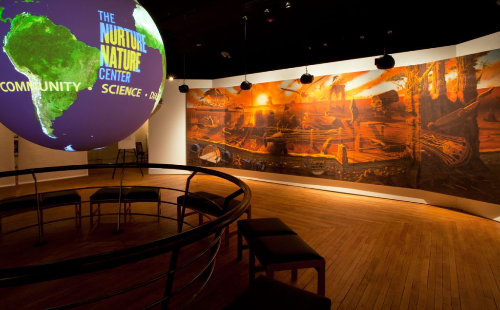 The Nurture Nature Center’s Science on a Sphere<b>®</b> globe set against a wall mural of Alexis Rockman’s <i>Manifest Destiny. </i>Photo courtesy of the Nurture Nature Center.