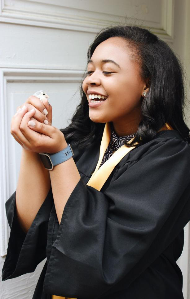 Lauren D. Pharr holding a blue-breasted quail named “Rio” that she raised and studied for her research.