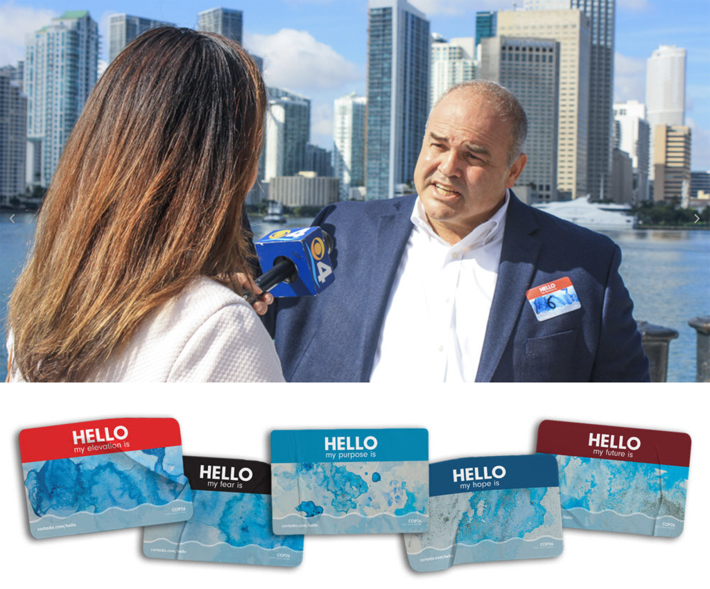 Artist Xavier Cortada explains his HELLO participatory art project to the media. Participants wear a HELLO name tag identifying the elevation of their home above sea level or their hopes for a sustainable future. ©2021 Xavier Cortada. Photos courtesy of the artist.